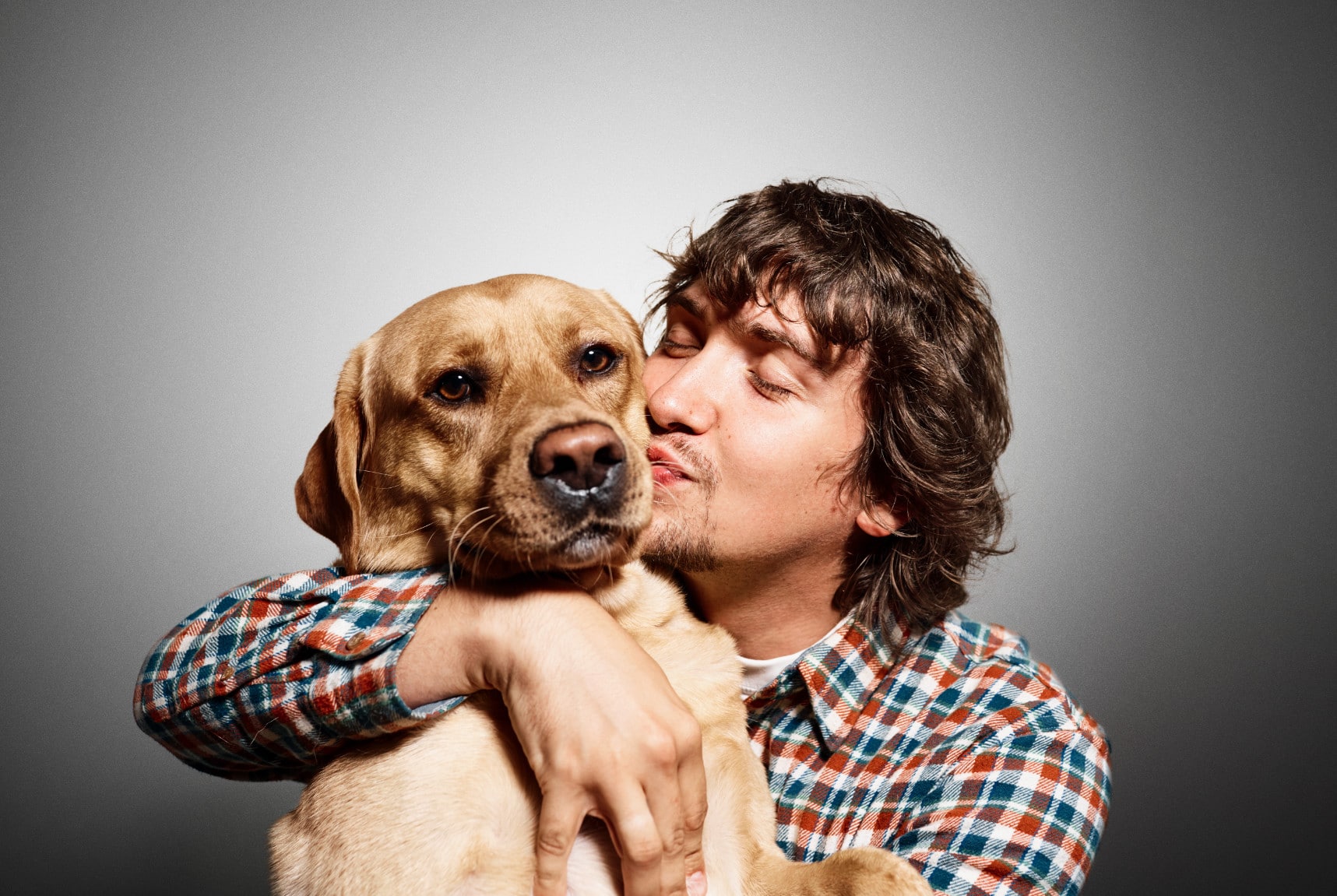 clear uncompressed image of man kissing dog